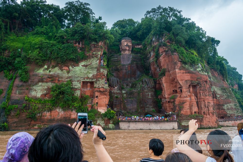 Tourists photographing the Giant Buddha, the largest buddha of the world carved on Emei Shan, sacred mount, Leshan, Sichuan, China