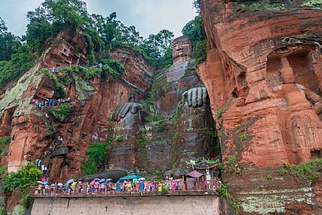 Tourists admiring the Giant Buddha, the largest buddha of the world carved on Emei Shan, sacred mount, Leshan, Sichuan, China