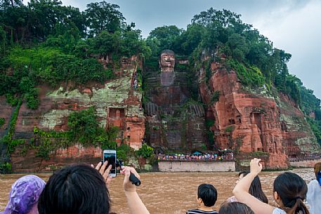 Tourists photographing the Giant Buddha, the largest buddha of the world carved on Emei Shan, sacred mount, Leshan, Sichuan, China