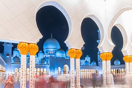 People in the courtyard of of Sheikh Zayed Grand Mosque in the City of Abu Dhabi at twilight, Emirate of Abu Dhabi, United Arab Emirates, UAE