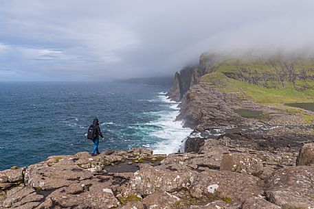 Tourist walkingo on the Sørvágsvatn or  Leitisvatn cliffs, Faeroe Islands, Denmark, Europe