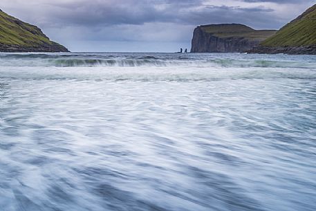 Wild sea and in the background the sea stacks of Risin and Kellingin, just off the northern coast of the island of Eysturoy from Tjornuvik village, Streymoy island, Faeroe islands, Denmark, Europe