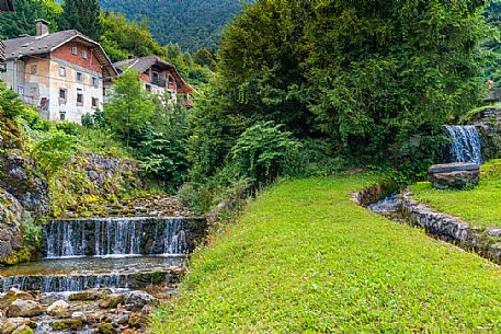 River and traditional houses in the Kropa village, Radovljica, Slovenia, Europe