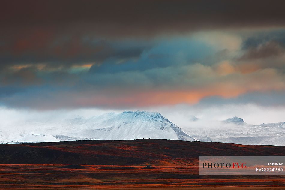 Lava fields and snow covered mountains in the last light of day