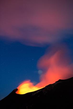 Smoke and fire from the crater light up the starred sky
